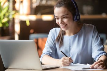 Mujer tomando un curso de capacitación en una computadora portátil en su escritorio